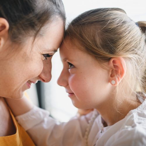 Mother and child indoors at home, hugging