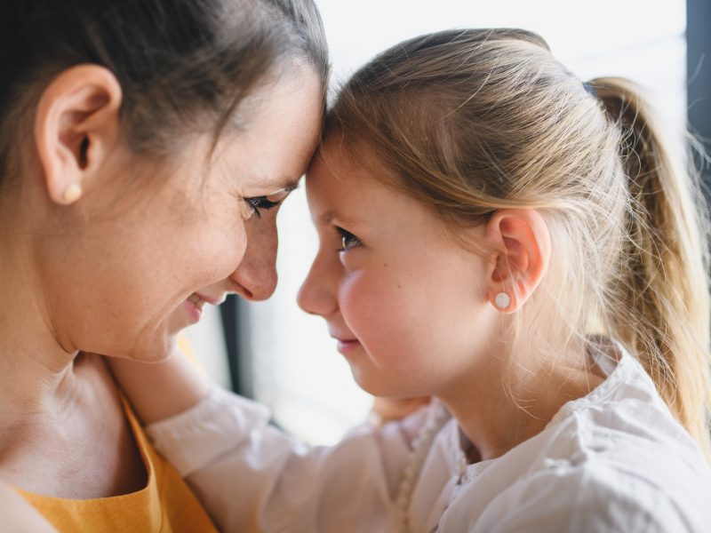Mother and child indoors at home, hugging