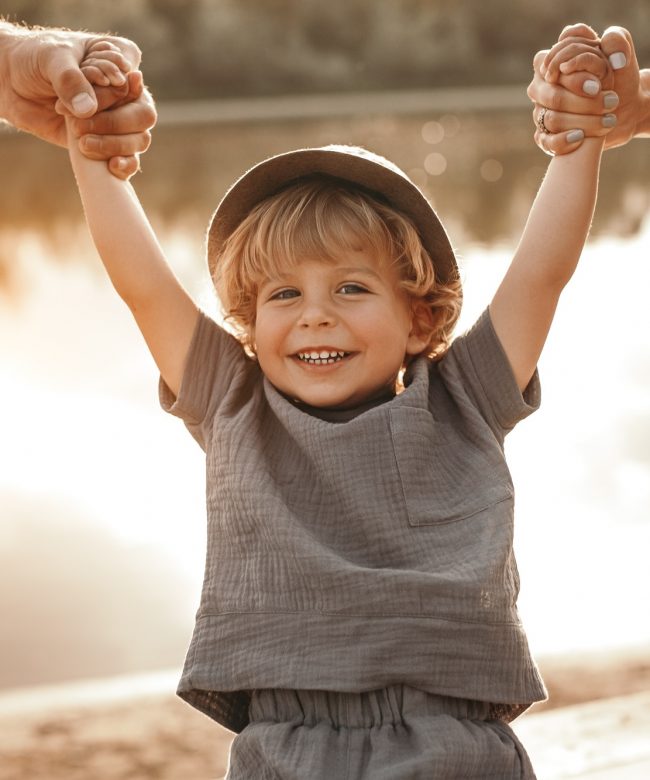 Parents holding hands of smiling child